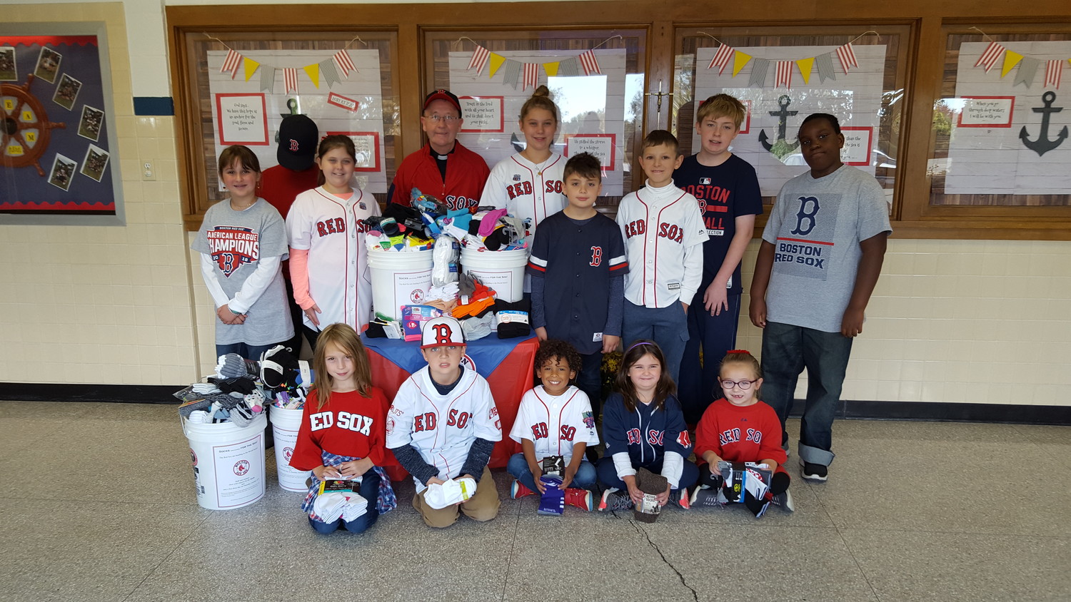 All Saints STEAM Academy in Middletown celebrated the Red Sox playing in the World Series by holding a Socks for the Sox collection. Students brought in socks and gloves that will be donated to a local charity. Father Francis O’Loughlin, a loyal Red Sox fan and pastor of Jesus Saviour and St. Joseph Churches, was on hand to celebrate a successful drive by the students to help those in need.